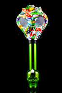 Green skull-base acrylic bong paired with bright cartoon zombie decal gas mask with eye windows.