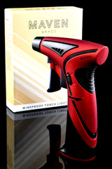 Red and black Maven Space torch lighter with ergonomic grip and chrome nozzle, posed beside retail box on glossy black surface.