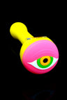 Yellow and pink silicone pipe with large stylized eyeball cap and clear glass bowl insert.