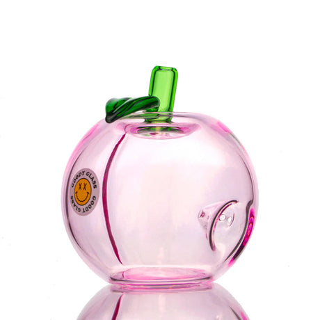 Pink peach-shaped glass hand pipe with green stem, leaf detail, and Goody Glass produce sticker