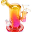 Yellow and red metallic glass mini bong with jewel grip, 14 mm joint, and round foot base, 5″ tall.