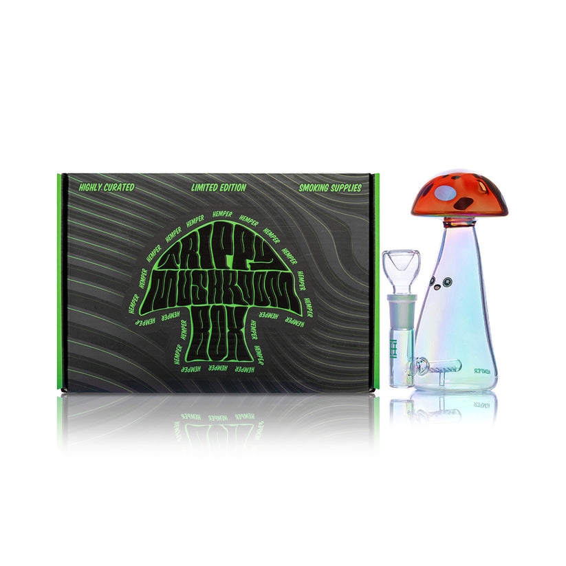 Side view of Hemper Trippy Shroom 6-inch iridescent glass bong and matching bowl posed beside branded Trippy Mushroom box on white studio backdrop.