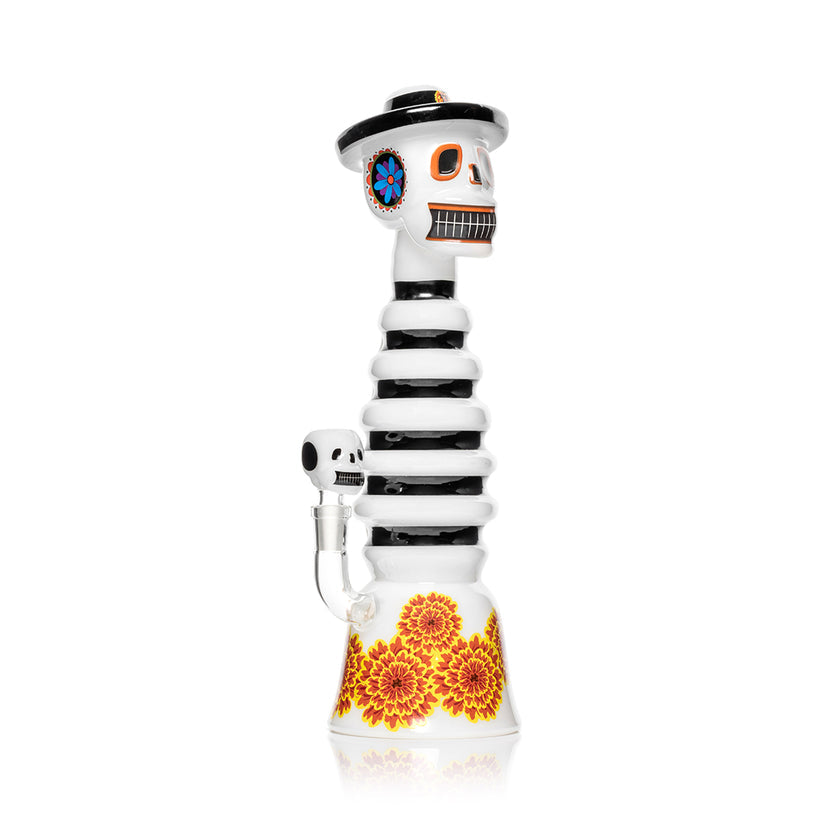 Side view Hemper Dia De Los Muertos XL glass bong with ribbed neck, skull bowl and marigold flowers around the flared base.