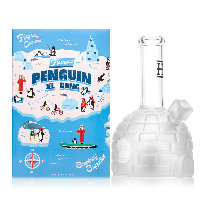 Front view of frosted igloo Penguin XL glass bong standing beside illustrated Hemper Penguin XL Bong box, styled for smoke shop product listings.