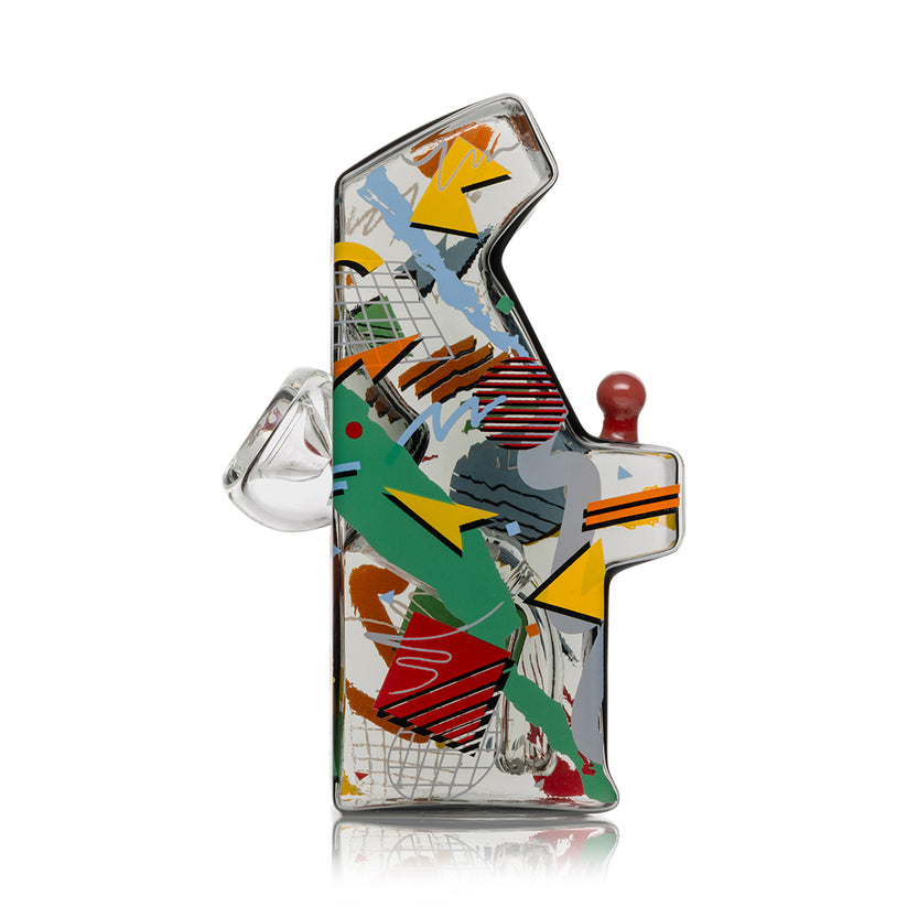 Side angle of Hemper Totally Rad arcade glass bong highlighting multicolor 80s-style geometric artwork and angled mouthpiece.
