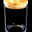 Large cylindrical glass storage jar featuring wide bamboo pop-top lid and silicone seal, close-up on black backdrop
