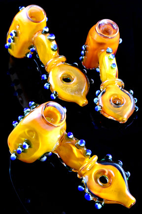 Gold-fumed donut-hole hammer bubbler on black background showing ringed donut grip and marble accents, 6.5 inches.