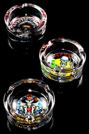 Set of pop-art skull design tempered glass ashtrays, staggered layout showcasing full print detail on black backdrop.