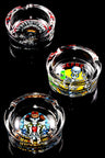 Set of pop-art skull design tempered glass ashtrays, staggered layout showcasing full print detail on black backdrop.