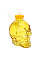 Yellow 4-inch skull-shaped glass bong with matching cap, clear herb slide, and angled glass mouthpiece on white backdrop