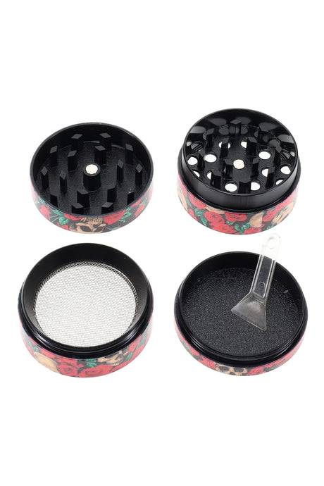 Four-piece 1½″ metal herb grinder from the gift set shown disassembled with fine mesh kief screen and scraper included.