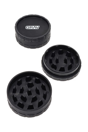 Black GRAV 2.5″ hemp-plastic 2-piece herb grinder with sharp teeth, shown open and closed on a clean white background.