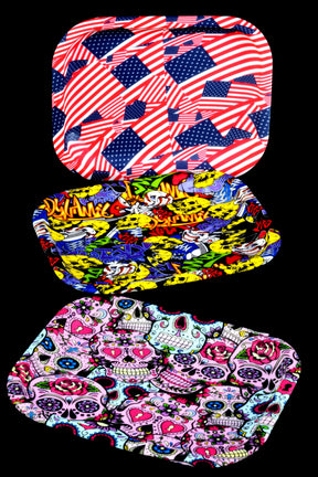 Small silicone rolling tray with flag collage and bold graphics, 8″ × 6″; curved rim helps corral papers and accessories.