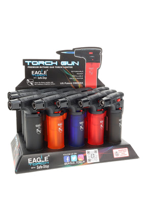 15-pack Eagle torch gun butane lighters in counter display with Safe-Stop flame lock; assorted dark translucent colors.