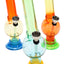 Three 6-inch multicolor acrylic bongs with suction bases and grommeted metal bowls, compact bubble style for dry herb use.