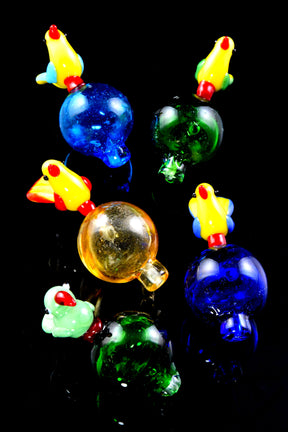 Assorted bird glass bubble carb caps on glossy black background with round bases and short tips; sold individually.