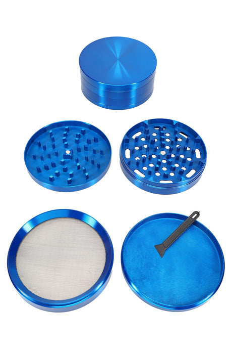 Blue 100 mm 4-part zinc alloy herb grinder disassembled to show diamond-cut teeth and pollen screen.