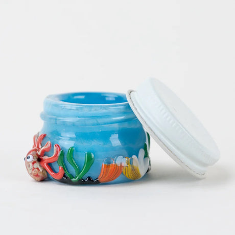 Blue under-the-sea terp jar with white screw lid placed on its side, revealing full coral reef artwork and spacious glass interior on white backdrop