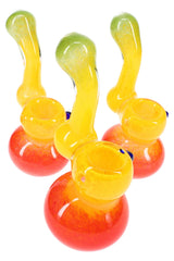 Three rasta frit sherlock glass bubblers showing carb holes and rounded bases in green, yellow, and red fade