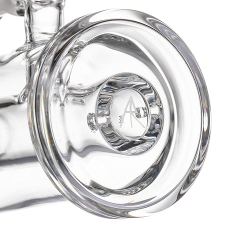 Close-up of MJ Arsenal mini dab rig base with thick clear glass footing and etched logo detail