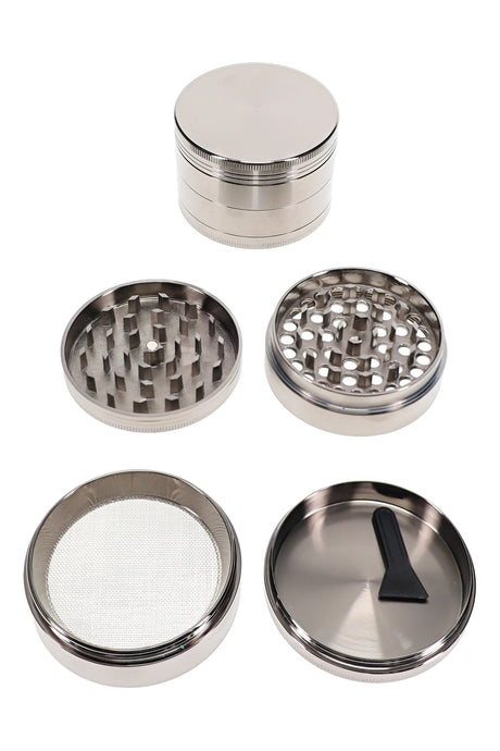 Open 4-part metal herb grinder with teeth, screen chamber, scraper, and large 2.5 inch body