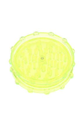 Neon yellow acrylic magnetic 2-piece grinder showing clear chamber and uniform peg teeth.