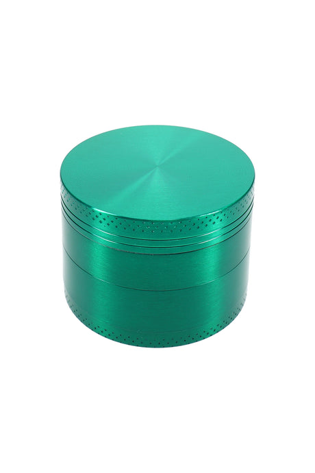 Green 2″ 4-part metal herb grinder with brushed lid and knurled edge, closed top view on white background