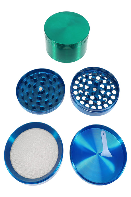 Exploded view of 63 mm 4-part metal herb grinder showing teeth, shredder plate, screen, and scraper tool