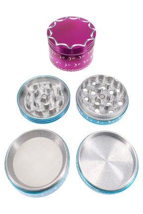 Colorful 4-part aluminum herb grinder with scalloped lid and moon accents; disassembled to show teeth, mesh screen, and catcher.