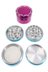 Colorful 4-part aluminum herb grinder with scalloped lid and moon accents; disassembled to show teeth, mesh screen, and catcher.