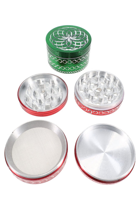 Green-top 4-part aluminum herb grinder with geometric lid engraving and red body, shown apart with grinding plates and kief screen.