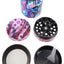 Color-splash zinc alloy 4-part herb grinder with printed exterior, diamond teeth, fine mesh screen, and scraper tool shown apart.