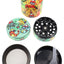 Cartoon-style wrap design zinc alloy 4-part weed grinder; disassembled with perforated plate, mesh screen, and pollen tray.