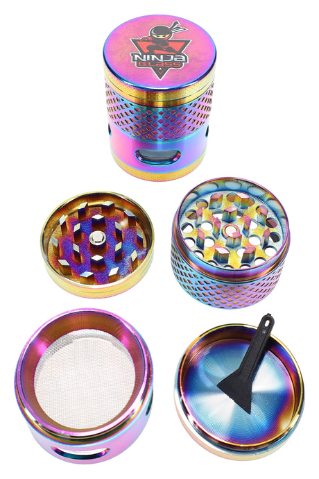 Rainbow windowed 4-part metal herb grinder by Ninja Glass, 1½″ size with kief screen and scraper, pieces shown disassembled.
