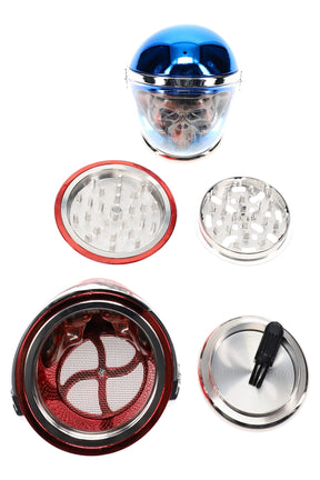 Skull astronaut metal herb grinder disassembled, 2¼″ 4-part aluminum design with diamond teeth, mesh screen, kief catch and scraper tool.