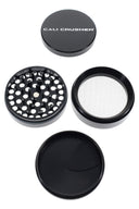 Black Cali Crusher O.G. grinder disassembled into 4 parts with precision teeth, fine mesh kief screen, and scraper.