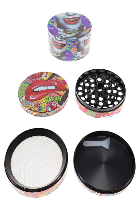 Pop-art lips metal herb grinder opened with black teeth, mesh screen, tray, and gray scraper