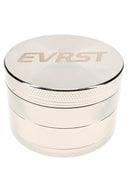 Silver EVRST metal herb grinder opened to show teeth, mesh screen, collection tray, and scraper