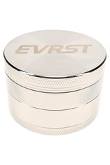 Silver EVRST metal herb grinder opened to show teeth, mesh screen, collection tray, and scraper