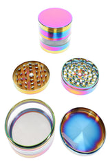 Open rainbow metal herb grinder showing sharp teeth, screen, pollen chamber, and scraper tool