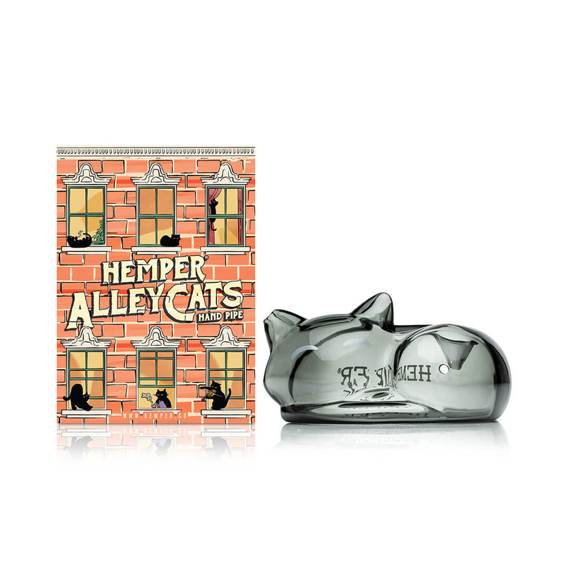 Front view of Hemper Alley Cats hand pipe beside colorful brick-theme box, highlighting the smoky gray sleeping cat glass design.