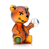 Side profile of Hemper Scare Bears 5.5-inch teddy bear glass bong showing frosted amber body, raised stitches and clear herb bowl.