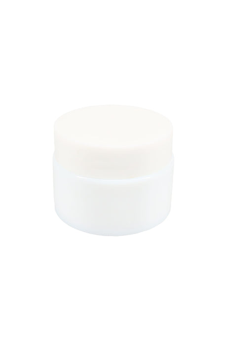 Side-angle view of small opaque white glass concentrate jar with threaded lid, showing compact squat profile against white backdrop