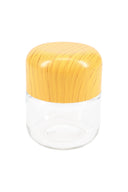 Small clear glass stash jar with rounded wood-grain tamper-evident lid, centered on white background, perfect for cannabis flower or edibles