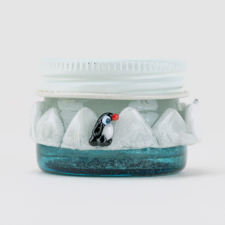 Empire Glassworks arctic concentrate jar with penguin accent, snowy rim, and blue glass base
