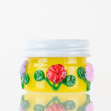 Empire Glassworks Sunshine Garden terp jar with yellow glass body, white lid, and raised flowers