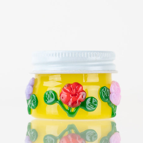 Empire Glassworks Sunshine Garden terp jar with yellow glass body, white lid, and raised flowers