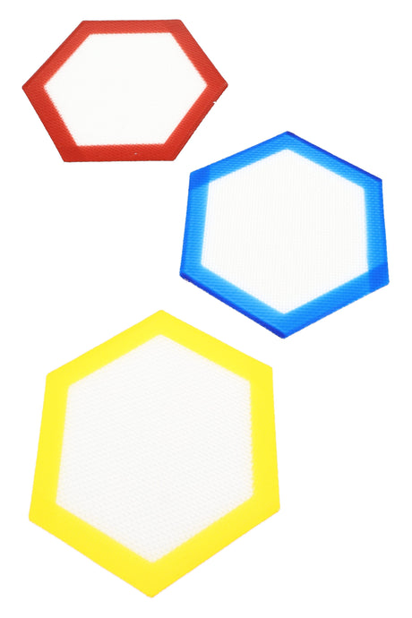 Trio of hexagon silicone dab mats in red, blue, and yellow with white non-stick centers, arranged on white backdrop for color comparison.