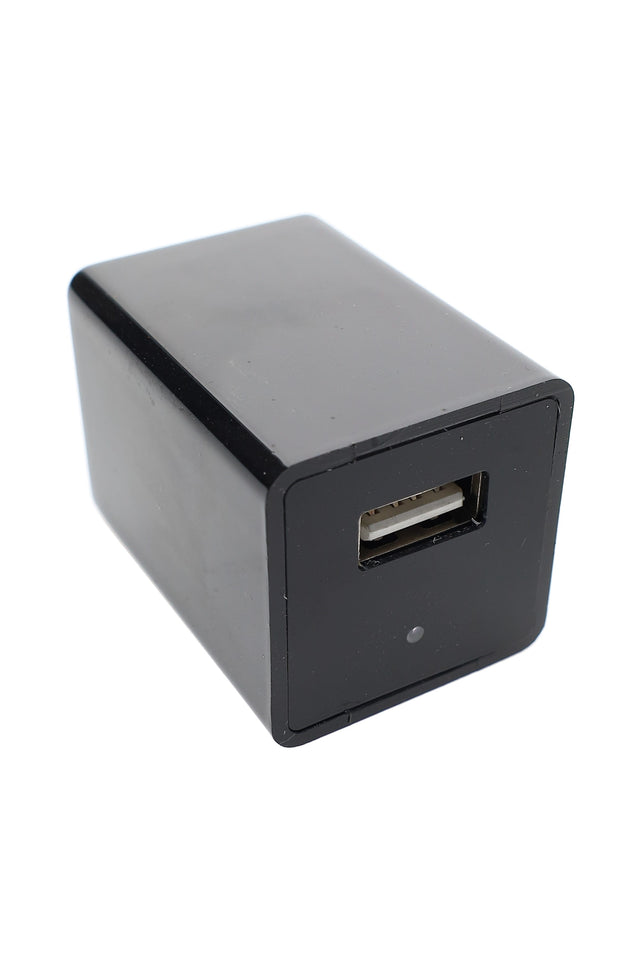 Black USB wall charger with hidden camera lens and single USB-A port, angled view on white background, compact rectangular design