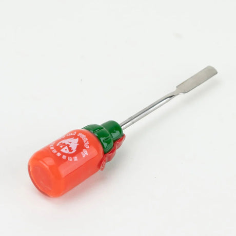 Angled shot of Sriracha glass dab tool lying down, focusing on red bottle base with white Vietnamese text logo and wide steel blade tip.